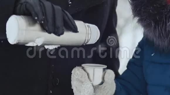 年轻的爱人在冬天的公园里取暖视频的预览图