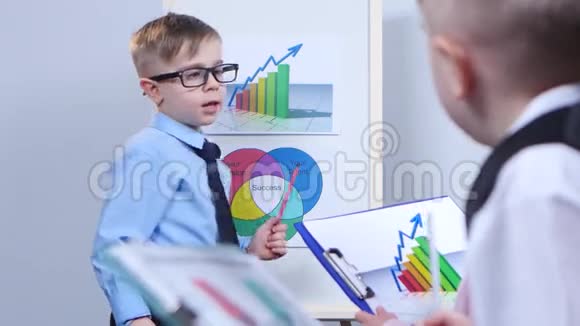 小商人指着图表坐在孩子们旁边考虑图表视频的预览图