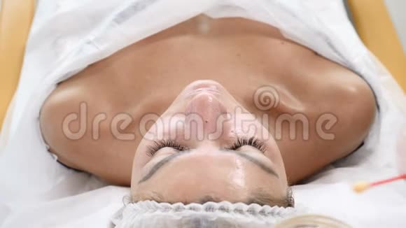 美的概念年轻女性客户获得美容面部手术面部翻新美容师用棉芽覆盖视频的预览图