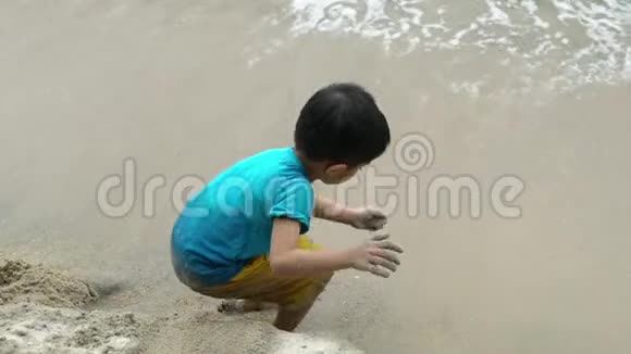 亚洲马来西亚男孩在海滩上玩沙子视频的预览图