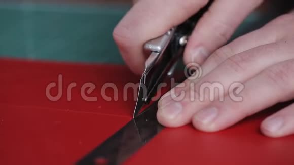 近距离拍摄一个皮革工匠切割需要的块皮从大的他用的是刀和直刃视频的预览图