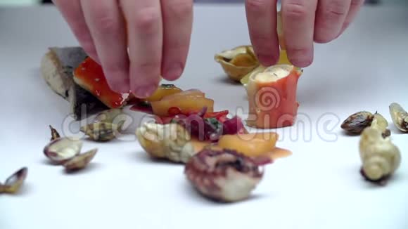 手用水果海鲜装饰在一张白色光滑的桌子上视频的预览图