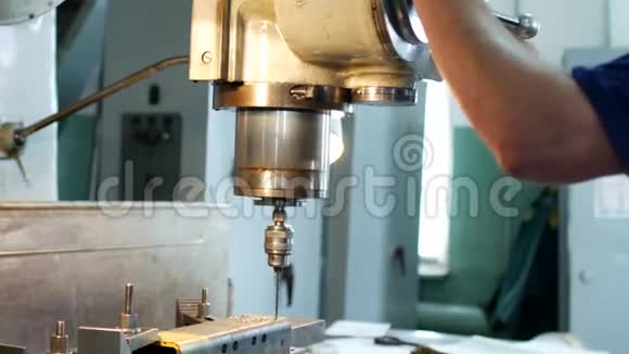 一个人专门在一台金属工件上的钻床上钻洞这是个小生意视频的预览图