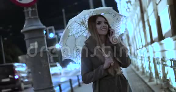 年轻女子撑着伞走路说话视频的预览图