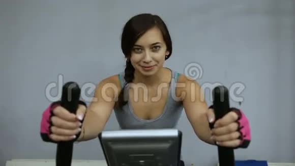 那个女孩在健身房骑着运动自行车接受训练视频的预览图