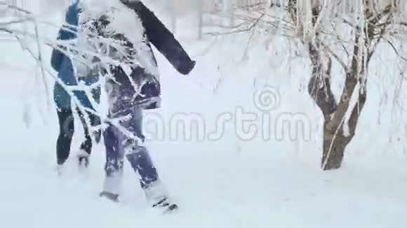 一个男人和一个女孩在一棵树上玩追赶游戏然后他们躺在雪地里视频的预览图