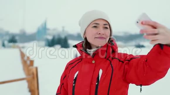 穿红色夹克的美女在冬天自拍视频的预览图