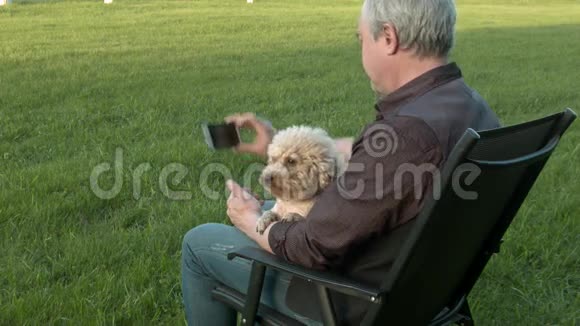 男人和一只狗坐在椅子上自拍视频的预览图