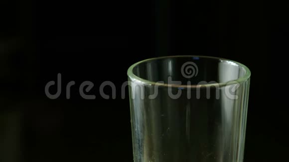 碳酸苏打饮料黄色倒入杯中黑色背景特写半个玻璃视频的预览图