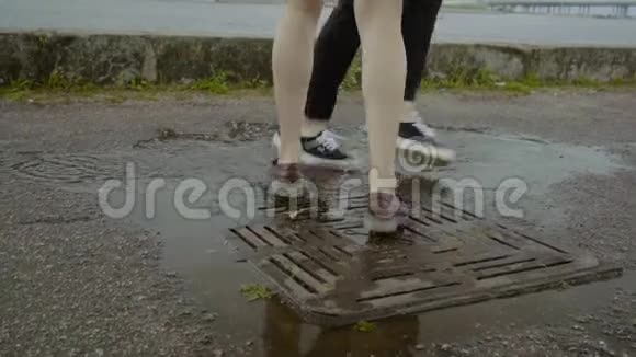 夏天女性和男性的双脚在下水道的雨水池里跳舞视频的预览图