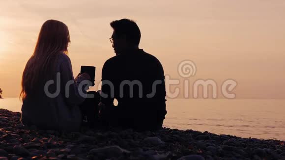 技术的本质亚洲男人戴眼镜女人休息自然享受平板电脑日落时分视频的预览图