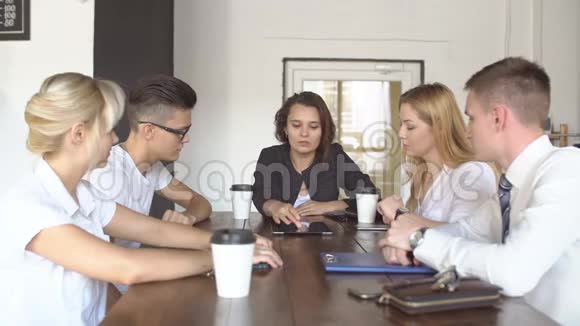 有创意的年轻团队一起喝咖啡拿着桌子讨论项目团队合作咖啡屋在线商务视频的预览图