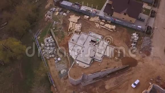 在新的现代化小屋附近正在进行的施工现场的鸟瞰图建筑材料和工人的浇筑视频的预览图