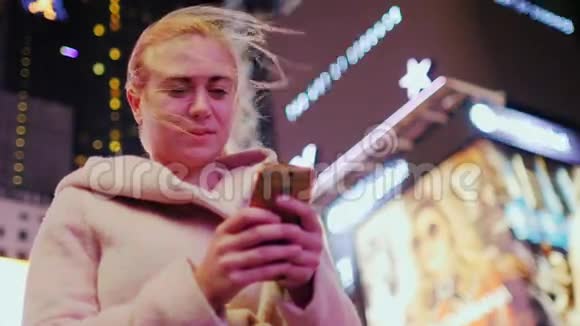 在霓虹灯的领域纽约市时代广场上一位带电话的年轻女子视频的预览图