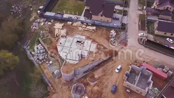 建筑工地附近的新的现代化别墅的鸟瞰图建筑材料和工人为建筑工地浇筑混凝土视频的预览图