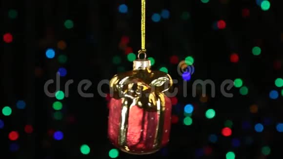 红色圣诞球摆动在离焦背景与闪烁的花环灯视频的预览图