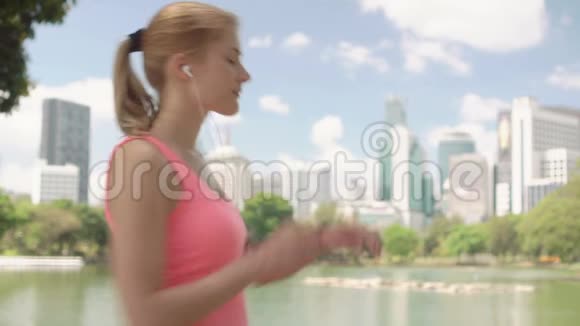 女子跑步者在公园慢跑适合女性运动健身跑步训练使用智能手表视频的预览图