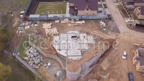 建筑工地附近的新的现代化别墅的鸟瞰图建筑材料和工人为建筑工地浇筑混凝土视频的预览图