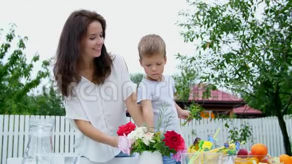 夏天在花园里妈妈和一个四岁的儿子做了一束花这个男孩非常喜欢它他很高兴视频的预览图