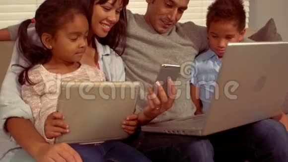 在不同的设备上微笑西班牙裔家庭视频的预览图