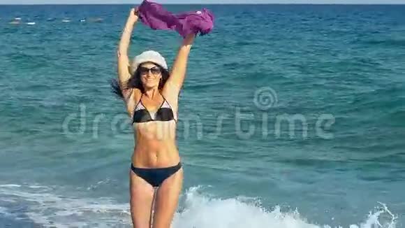 快乐的女孩跳着跳着在海滩上跳舞女人享受风自由假期暑假的乐趣概念视频的预览图