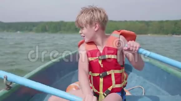 那家伙漂浮在船上青少年在桨的帮助下独立操作一艘船极限运动视频的预览图