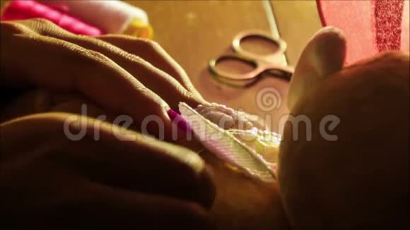 特写女士双手在桌上缝蝴蝶翅膀视频的预览图