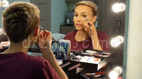 化妆师在线教育化妆艺术一个女孩正在牵着一条小溪在她的脸上涂上粉末视频的预览图