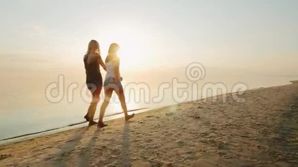 妈妈和女儿是日落时在海滩上的青少年背面视频的预览图