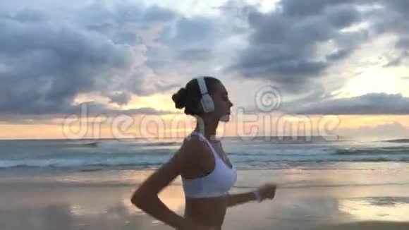 一个女孩在靠近水的沙滩上奔跑视频的预览图