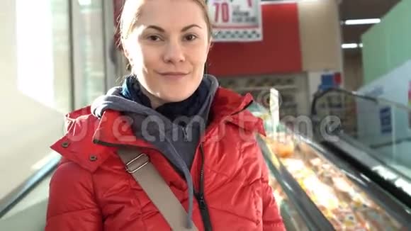 美丽迷人的年轻女子穿着红冬衣在商场里扶梯向上移动购物销售视频的预览图