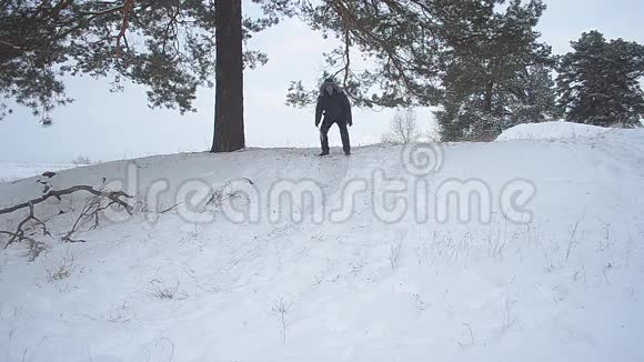 一个人在冬天的公园里的雪橇上驾驶一座雪山一个家庭在冬天的树林里度假视频的预览图