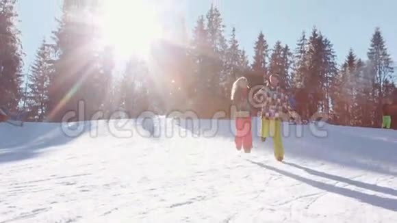可爱的女孩和英俊的黑发男子冬季运动服年轻可爱的一对夫妇牵着手跑着视频的预览图