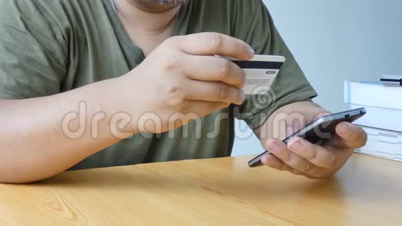 近距离接触使用智能手机和持有信用卡隐喻互联网购物移动应用和电子商务的人视频的预览图