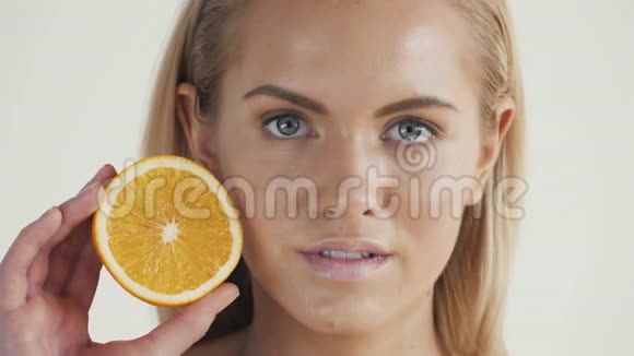 健康生活方式的好食物美丽的年轻无衫金发女子眼前捧着一块橘子视频的预览图