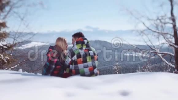 年轻人穿着时尚的冬季服装英俊的小男孩坐在他可爱的女朋友的额头上亲吻他视频的预览图