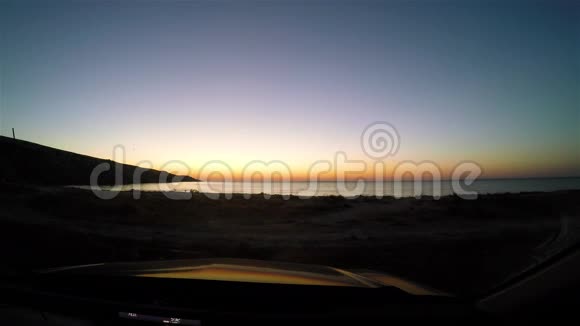 日出的时间从海上从汽车挡风玻璃上落下视频的预览图