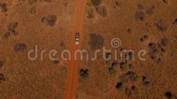 鸟瞰SUV与人们在纳米比亚大草原的道路上旅行视频的预览图