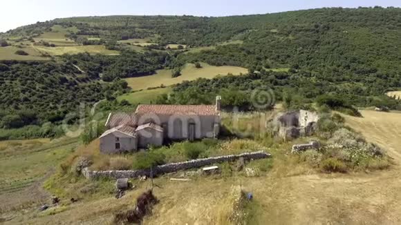 鸟瞰鸟眼的古老的废墟教堂在田野中间与干草捆视频的预览图