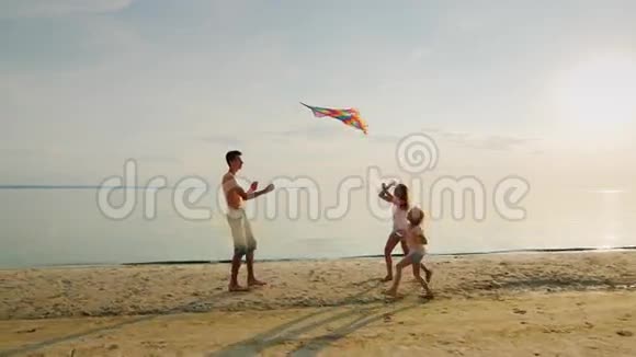 哥哥正在和妹妹们玩带着风筝跑步女孩们正在追赶他快乐视频的预览图