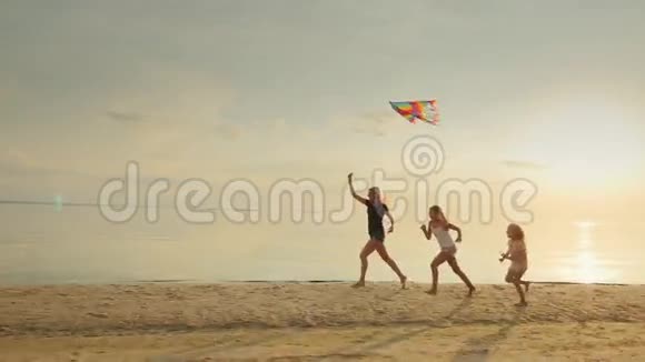 妈妈带着两个女儿在沙滩上玩风筝好玩的一起跑视频的预览图