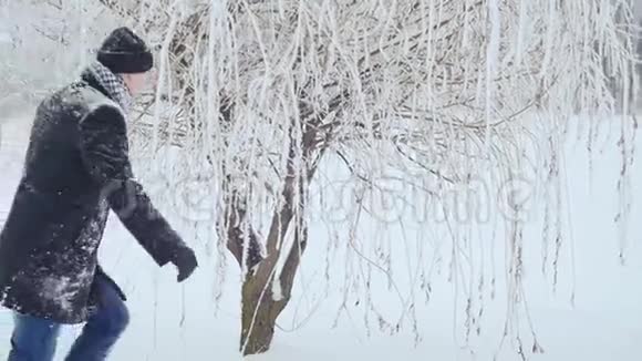 一个男人和一个女孩在一棵树上玩追赶游戏然后他们躺在雪地里视频的预览图