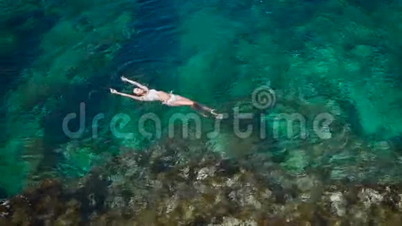 一位躺在海浪中的年轻女士视频的预览图