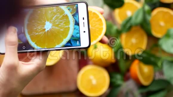 一个女人用电话给橘子拍照希普斯特为Instagram拍照视频的预览图