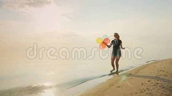 无忧无虑的年轻女人在海滩上奔跑手里拿着气球概念安逸自由快乐视频的预览图
