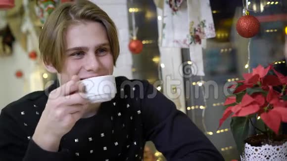 他是一个迷人的年轻人的肖像他坐在咖啡馆里对他的女朋友微笑金发男人在说视频的预览图