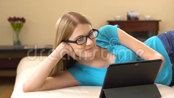 美丽迷人的年轻女子穿着一件蓝色的t恤通过一个混乱的人与朋友交流视频的预览图