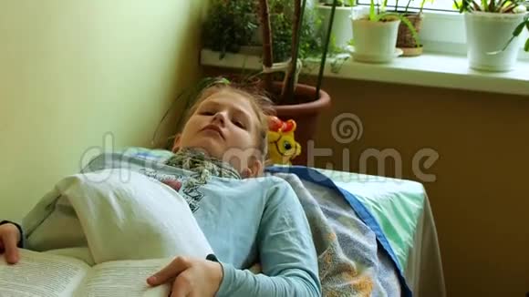 脖子上有蛔虫的女孩躺在床上手里拿着书视频的预览图
