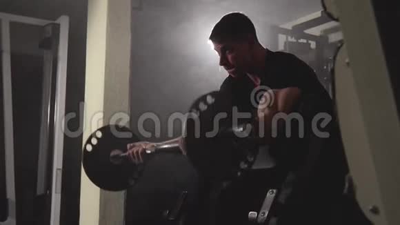 强壮的年轻肌肉男性健美运动员在健身房锻炼二头肌和大哑铃视频的预览图
