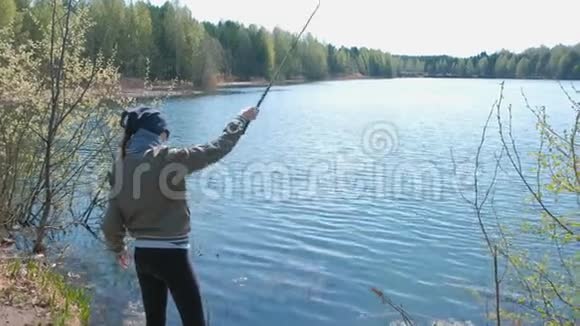 在温暖的春天女人在池塘上钓鱼视频的预览图
